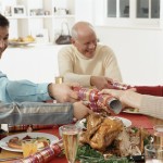 Family Pulling Party Favors During Christmas Dinner