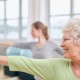 Close-up shot of elderly woman doing stretching workout at yoga class. Women practicing yoga at health club.
** Note: Shallow depth of field